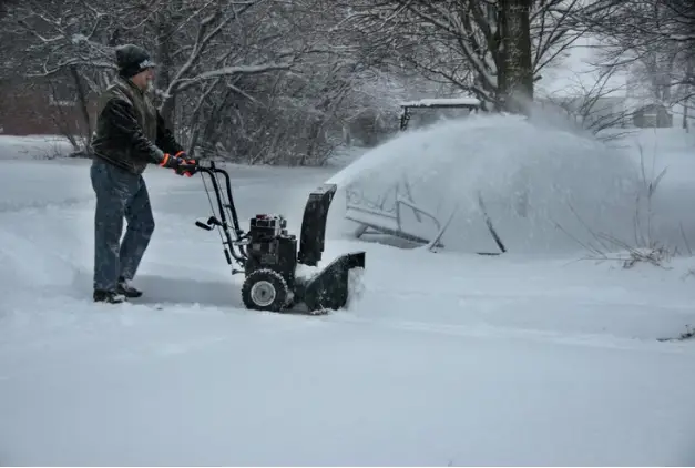 Snow blower clearing snow on public sidewalk